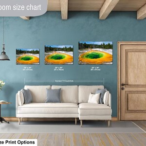 May include: A living room size chart displaying three rectangular canvas prints of the Grand Prismatic Spring in Yellowstone. The prints are labeled with dimensions 16x24 inches, 20x30 inches, and 24x36 inches, shown above a beige sectional sofa.