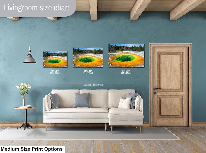 May include: A living room size chart displaying three rectangular canvas prints of the Grand Prismatic Spring in Yellowstone. The prints are labeled with dimensions 16x24 inches, 20x30 inches, and 24x36 inches, shown above a beige sectional sofa.