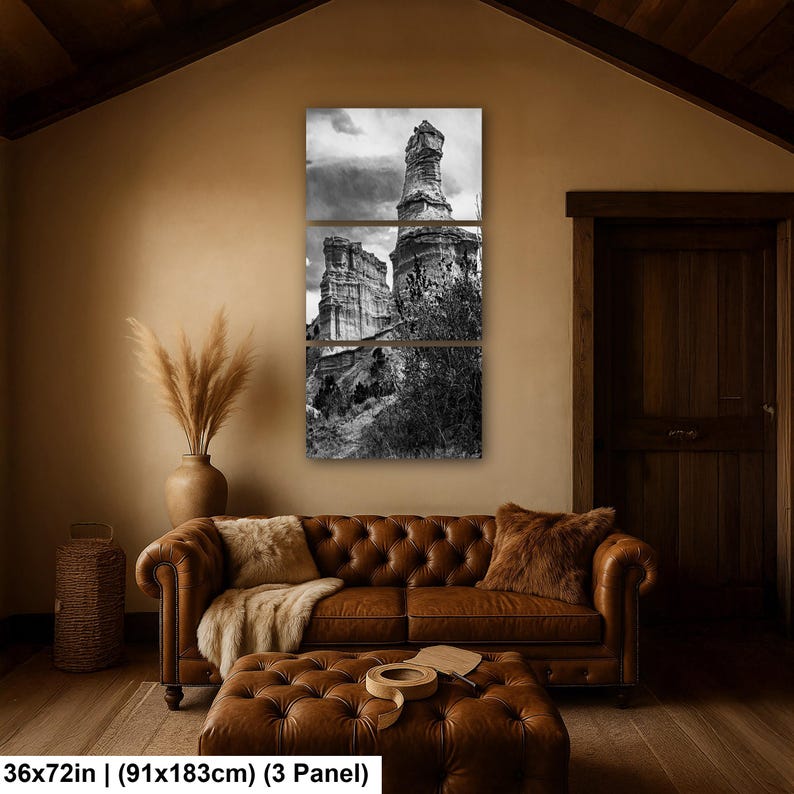 May include: A three-panel black and white wall art set depicting a tall rock formation and desert landscape. The artwork is labeled with dimensions of 36x72 inches. The panels are arranged vertically to form a single cohesive image of the terrain.