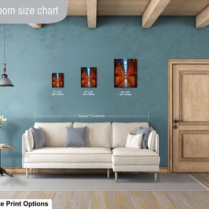 May include: A living room size chart displaying three rectangular wall art prints in sizes 8x10 inches, 11x14 inches, and 16x20 inches, positioned above a cream-colored sectional sofa. The prints feature a perspective view of a library interior.
