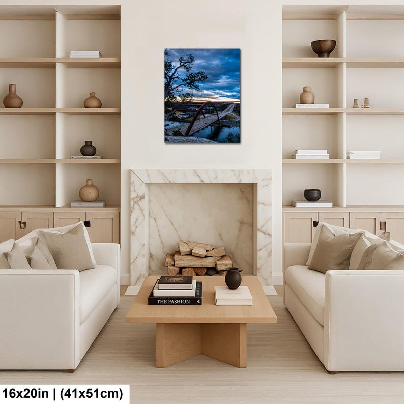 May include: A rectangular wall art print featuring a landscape photograph of a red arched bridge spanning a river at dusk. The sky is filled with dark blue clouds and a hint of sunset light. The print measures 16 inches by 20 inches in size.