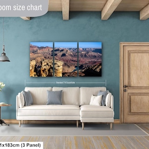 May include: A three-panel wall art set depicting a Grand Canyon landscape with rocky cliffs and a blue river, displayed above a cream-colored sectional sofa. The text "Livingroom size chart" and "36x72in | 91x183cm (3 Panel)" appear on the image.