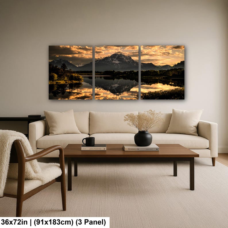 Puede incluir: Un conjunto de arte mural de tres paneles que representa un paisaje monta&ntilde;oso al atardecer con nubes doradas reflejadas en la superficie de un lago tranquilo. La obra mide 91 cm por 183 cm y muestra siluetas oscuras de &aacute;rboles y cumbres.