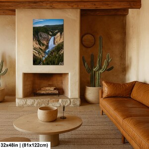 May include: A rectangular wall art print featuring a vertical landscape photograph of a waterfall cascading through a deep canyon with rocky cliffs and dense green pine forests under a blue sky, measuring 32 inches by 48 inches.