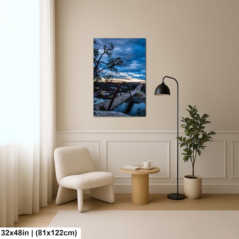 May include: A rectangular wall art print measuring 32 by 48 inches, featuring a landscape photograph of a large arched bridge spanning a body of water under a dramatic, dark blue cloudy sky at dusk, with silhouetted trees in the foreground.