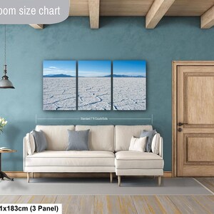 May include: A three-panel wall art set depicting a vast white salt flat under a clear blue sky with distant mountains. The artwork is displayed above a cream-colored sectional sofa. Text on the image includes Livingroom size chart and 36x72in.