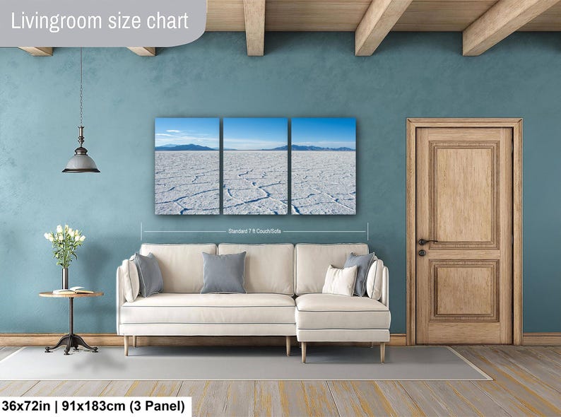 May include: A three-panel wall art set depicting a vast white salt flat under a clear blue sky with distant mountains. The artwork is displayed above a cream-colored sectional sofa. Text on the image includes Livingroom size chart and 36x72in.
