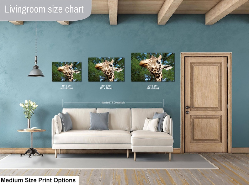 K&ouml;nnte beinhalten: Eine Gr&ouml;&szlig;entabelle f&uuml;r Wohnzimmer mit drei rechteckigen Wandbildern, die einen Giraffenkopf vor gr&uuml;nen B&auml;umen zeigen. Die Drucke sind mit den Ma&szlig;en 41x61 cm, 51x76 cm und 61x91 cm &uuml;ber einem beigen Sofa beschriftet.