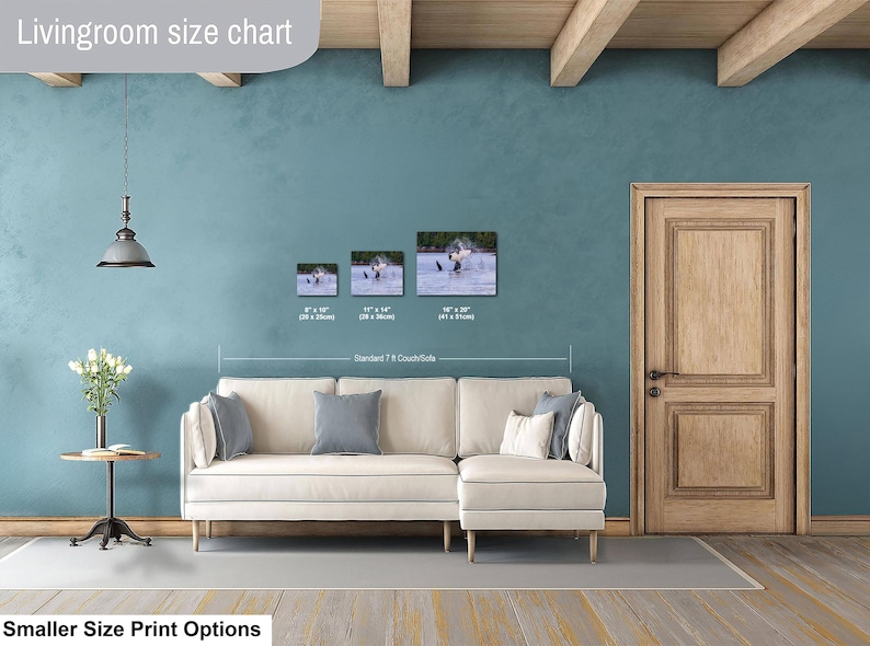 May include: A living room size chart displaying three rectangular wall art prints featuring a bird in water, labeled with dimensions 8x10 inches, 11x14 inches, and 16x20 inches, positioned above a cream-colored sectional sofa with gray accent pillows.