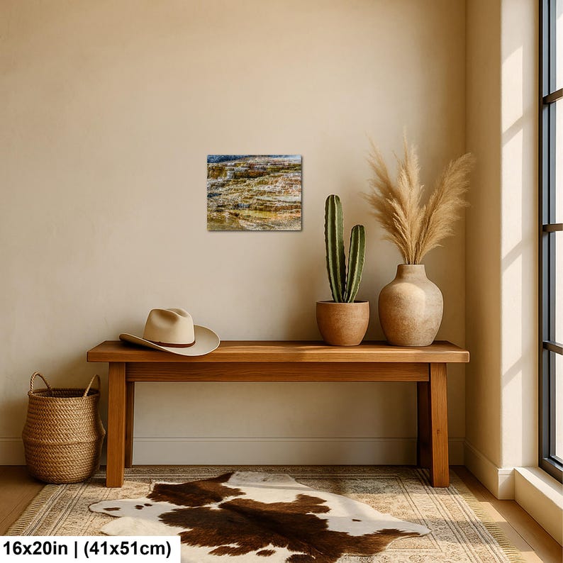 May include: A rectangular wall art print measuring 16 inches by 20 inches, featuring a landscape photograph of layered, mineral-rich rock formations in shades of brown, tan, and blue, displayed in a room with a wooden bench and decor.