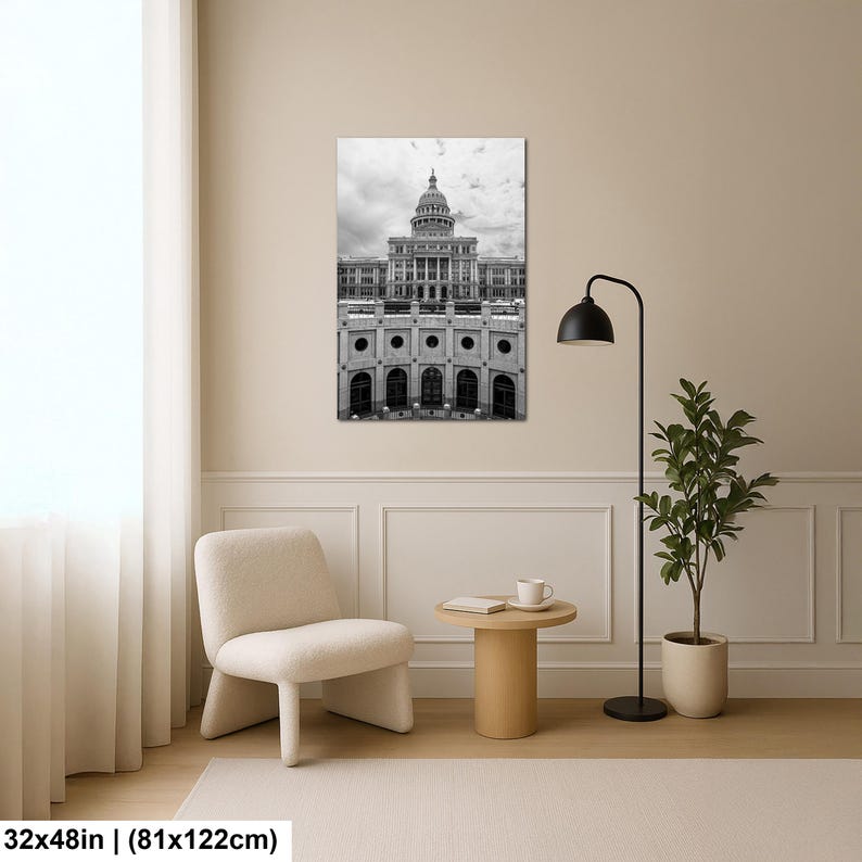 May include: A black and white wall art print featuring the Texas State Capitol building with its prominent dome and neoclassical architecture. The artwork measures 32 by 48 inches and is displayed in a room with a chair, table, and lamp.