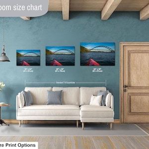 May include: A living room size chart displaying three rectangular wall art prints of a red kayak on water with a bridge in the background. The prints are labeled with dimensions of 16 by 24 inches, 20 by 30 inches, and 24 by 36 inches.