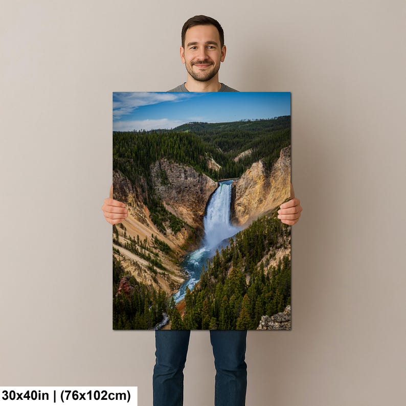 May include: A rectangular wall art print measuring 30 by 40 inches featuring a landscape photograph of a waterfall cascading into a deep canyon. The scene displays rocky cliffs, dense green pine forests, and a blue sky with light clouds.