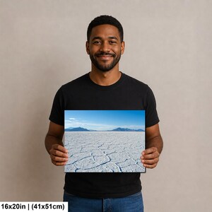 May include: A rectangular wall art print measuring 16 inches by 20 inches, featuring a landscape photograph of a vast white salt flat with a cracked surface texture, distant blue mountains, and a clear blue sky under bright daylight conditions.