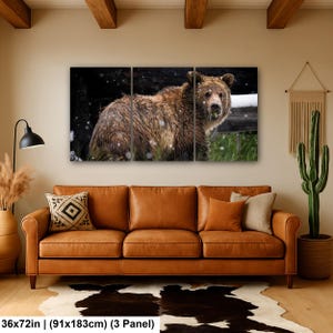 May include: A three-panel wall art set depicting a brown bear in a snowy forest environment. The artwork measures 91 by 183 cm and features the bear with thick fur, standing amidst green grass and light snowfall against a dark background.