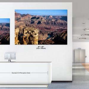 May include: Two rectangular wall art prints depicting the Grand Canyon landscape, featuring rocky cliffs and a river. The smaller print measures 30 inches by 40 inches, and the larger print measures 40 inches by 60 inches, displayed above a 5 ft desk.