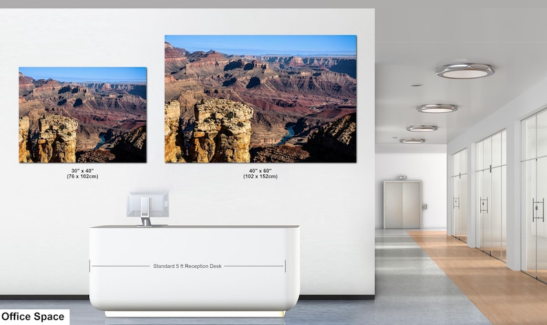 May include: Two rectangular wall art prints depicting the Grand Canyon landscape, featuring rocky cliffs and a river. The smaller print measures 30 inches by 40 inches, and the larger print measures 40 inches by 60 inches, displayed above a 5 ft desk.