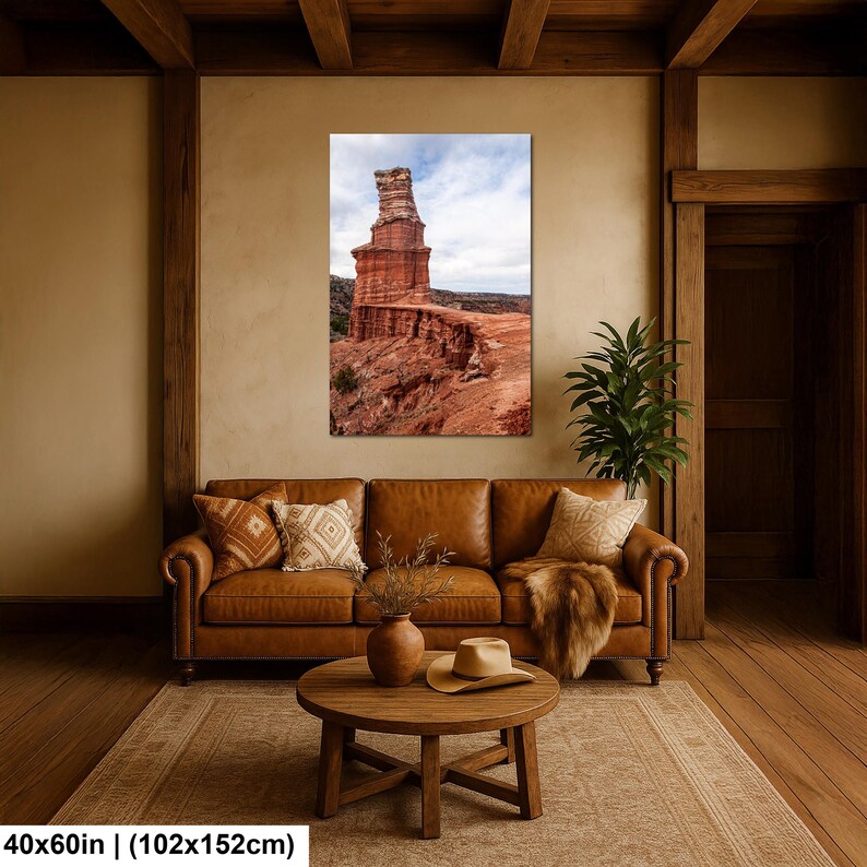 May include: A vertical wall art print featuring a tall, layered red rock formation under a cloudy sky, measuring 40 inches by 60 inches. The landscape photograph displays textured sandstone cliffs and desert terrain in shades of orange and brown.
