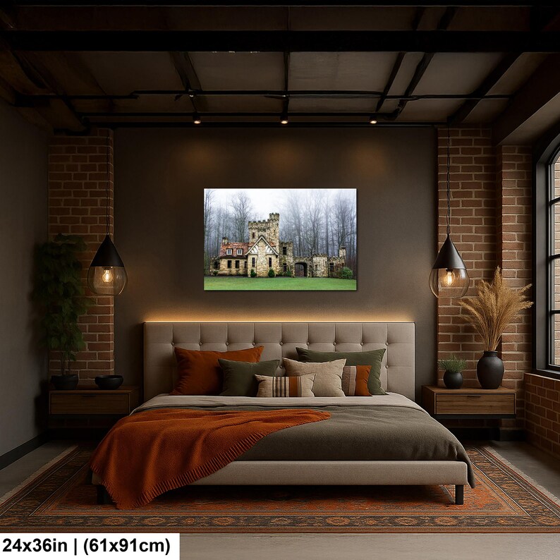 Op de afbeelding: Een rechthoekige wandkunstprint van 61 bij 91 cm met een stenen kasteel met een kanteltoren tegen een achtergrond van mistige, bladloze bomen en een groen gazon, opgehangen boven een gecapitonneerd hoofdeinde in een slaapkamer.