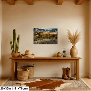 K&ouml;nnte beinhalten: Ein rechteckiger Wandkunstdruck mit einer Landschaft aus geothermischen Terrassen mit braunen, orangefarbenen und gelben Mineralablagerungen, 51x76 cm gro&szlig;. Der Druck h&auml;ngt an einer beigen Wand &uuml;ber einem dekorierten Holzkonsolentisch.