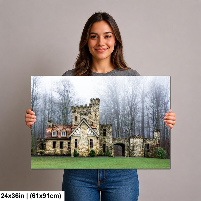 Op de afbeelding: Een rechthoekige wandkunstprint van 61x91cm met een stenen kasteel met een toren en een rood pannendak. Het bouwwerk staat tegen een achtergrond van hoge, kale bomen in een mistig bos, met een groen gazon op de voorgrond.