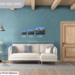 May include: A living room size chart displaying three rectangular wall art prints of a city skyline over water, with dimensions of 8x10 inches, 11x14 inches, and 16x20 inches, positioned above a white sectional sofa labeled as a standard 7-foot couch.