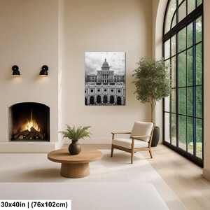 May include: A rectangular wall art print measuring 30 by 40 inches, featuring a black and white architectural photograph of the Texas State Capitol building with its prominent dome, displayed on a wall above a wooden coffee table and fireplace.