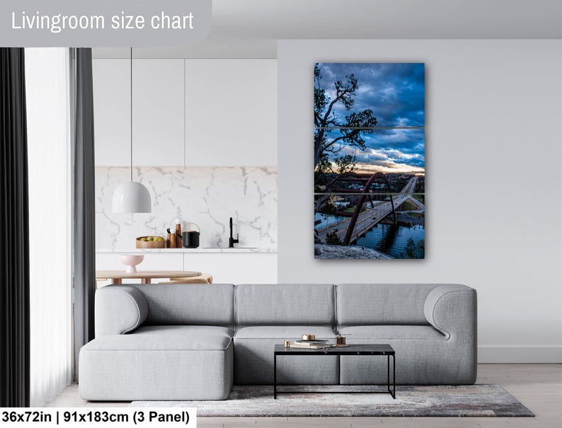 May include: A three-panel wall art set depicting a bridge over water at sunset under a cloudy blue sky. The artwork is displayed on a wall above a gray sofa. The text "Livingroom size chart" and "36x72in | 91x183cm (3 Panel)" is visible.