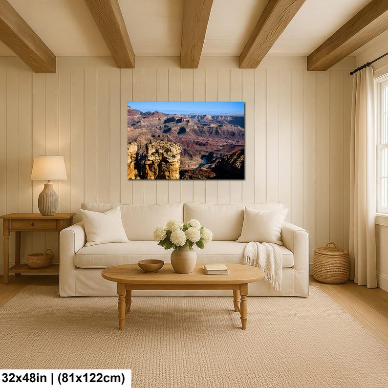May include: A rectangular wall art print featuring a panoramic landscape of the Grand Canyon with layered rock formations in shades of brown, red, and orange under a clear blue sky. The print measures 32 inches by 48 inches.