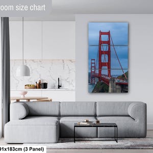 May include: A three-panel wall art set depicting the Golden Gate Bridge in red against a cloudy blue sky. The text Livingroom size chart is visible at the top, and the text 36x72in | 91x183cm (3 Panel) is visible at the bottom left.