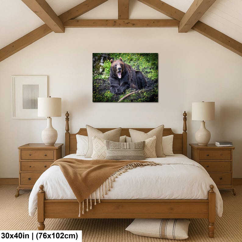 May include: A rectangular wall art print featuring a brown bear with its mouth open, resting in a green forest setting. The print measures 30 by 40 inches and is displayed above a wooden bed frame with a white duvet and a tan throw blanket.