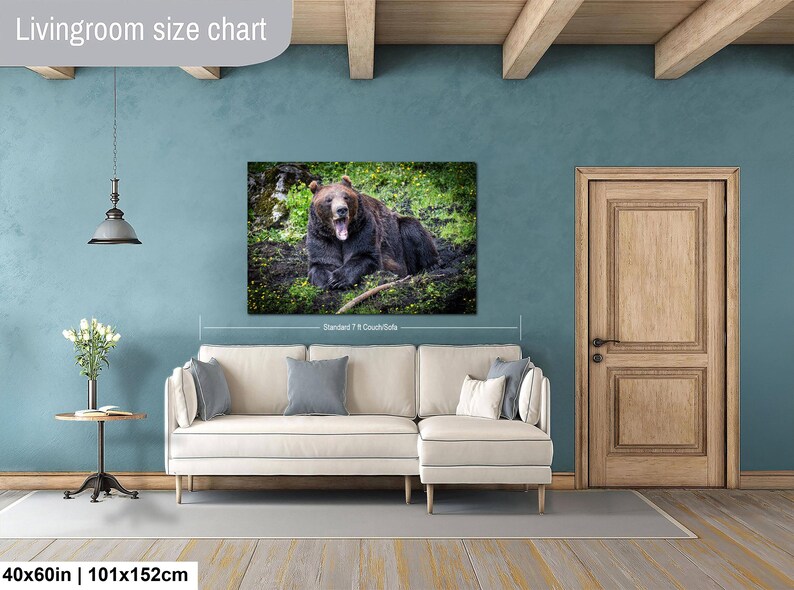 May include: A rectangular wall art print featuring a brown bear yawning in a grassy field, displayed above a cream-colored sectional sofa. The print is labeled as 40x60 inches and 101x152 cm, showing a standard 7-foot couch for scale reference.