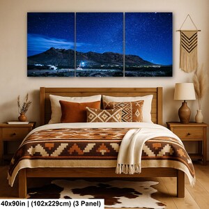 Puede incluir: Un conjunto de arte mural de tres paneles que representa un paisaje nocturno con una cordillera bajo un cielo azul estrellado. La obra mide 102 por 229 cm en total. La escena muestra la silueta oscura de las monta&ntilde;as contra un cielo nocturno.