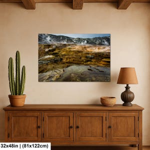 K&ouml;nnte beinhalten: Ein rechteckiger Wandkunstdruck mit den Ma&szlig;en 81 cm x 122 cm, der eine geothermische Landschaft mit terrassierten Mineralbecken in Orange-, Braun- und Gelbt&ouml;nen vor einer Kulisse aus dampfenden Bergen unter bew&ouml;lktem Himmel zeigt.
