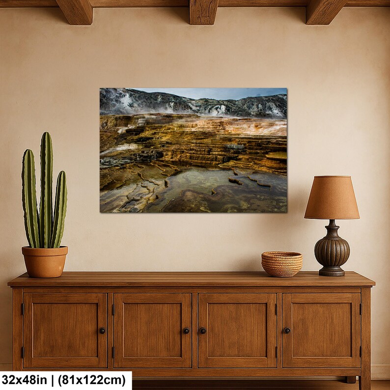 K&ouml;nnte beinhalten: Ein rechteckiger Wandkunstdruck mit den Ma&szlig;en 81 cm x 122 cm, der eine geothermische Landschaft mit terrassierten Mineralbecken in Orange-, Braun- und Gelbt&ouml;nen vor einer Kulisse aus dampfenden Bergen unter bew&ouml;lktem Himmel zeigt.