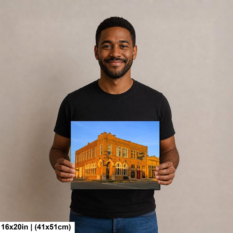 May include: A rectangular wall art print featuring a historic orange brick building under a clear blue sky. The print measures 16x20 inches and displays architectural details including arched windows and a corner entrance on a city street.