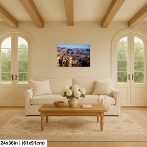 May include: A rectangular wall art print featuring a landscape photograph of the Grand Canyon with deep red rock formations, shadows, and a bright blue sky. The print measures 24 inches by 36 inches and is displayed on a neutral wall.