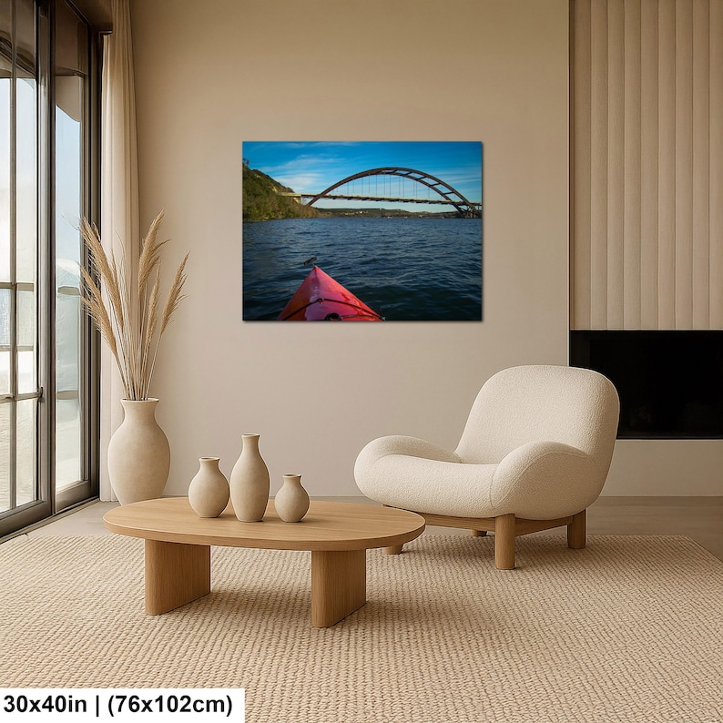 May include: A rectangular wall art print featuring a landscape photograph of a red kayak bow on dark blue water, facing a large arched bridge under a bright blue sky. The print dimensions are clearly labeled as 30 inches by 40 inches.