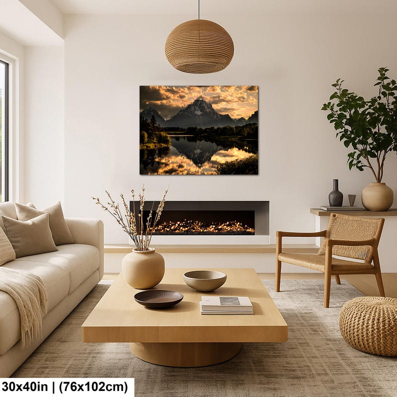 Puede incluir: Un cuadro rectangular de pared que mide 76 por 102 cm, con una fotograf&iacute;a de paisaje de una cordillera reflejada en un lago tranquilo al atardecer con nubes doradas, exhibido sobre una chimenea en un entorno de sala de estar.