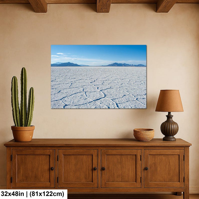 May include: A rectangular wall art print featuring a landscape of the Bonneville Salt Flats with a cracked white salt crust, distant blue mountains, and a clear blue sky. The print measures 32 inches by 48 inches as indicated by the text.