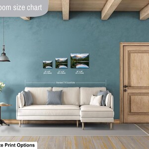 May include: A living room size chart displaying three landscape prints of a mountain lake above a cream-colored sectional sofa. The prints are labeled with dimensions 8" x 10", 11" x 14", and 16" x 20". Text includes "Livingroom size chart" and "Standard 7 ft Couch/Sofa".