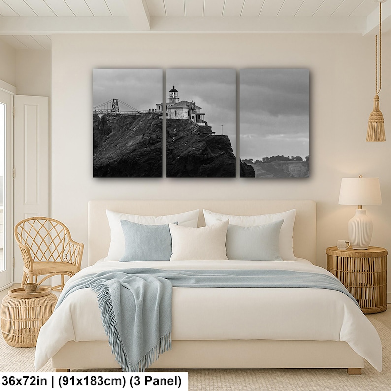 May include: A three-panel black and white canvas wall art set depicting a lighthouse perched on a rocky cliffside with a bridge structure in the background. The artwork measures 36 inches by 72 inches in total, featuring a cloudy sky and landscape.