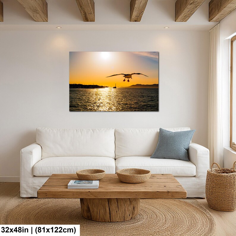 May include: A rectangular wall art print featuring a seagull in flight over a dark ocean at sunset. The golden sun hangs low on the horizon, casting a bright reflection across the rippling water. The print measures 32 inches by 48 inches.