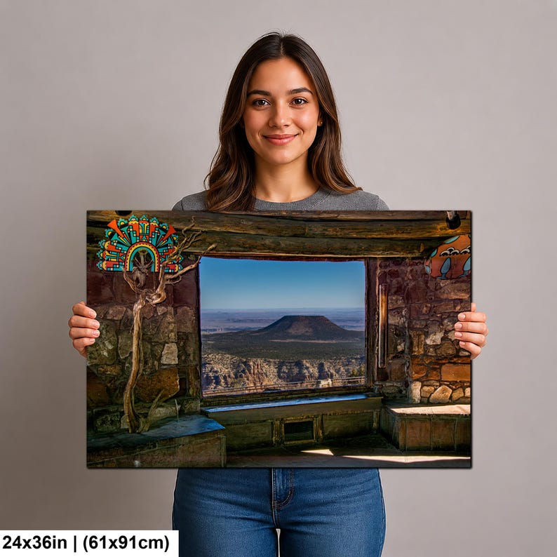 May include: A rectangular wall art print measuring 24 by 36 inches, featuring a view through a stone window frame looking out at a flat-topped mountain landscape. A decorative, colorful, fan-shaped ornament is attached to a branch on the left side.