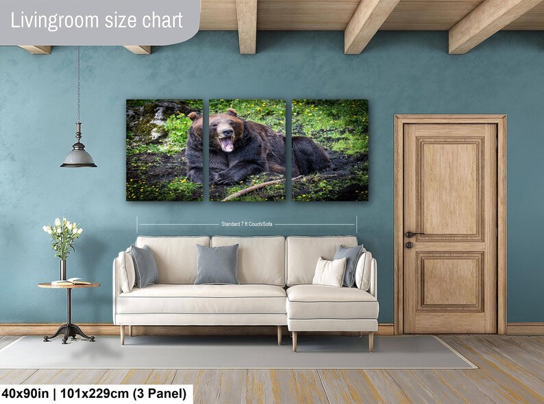 May include: A three-panel canvas wall art set featuring a brown bear yawning in a grassy field. The artwork is displayed above a cream-colored sectional sofa. The text "Livingroom size chart" and "40x90in | 101x229cm (3 Panel)" is visible.