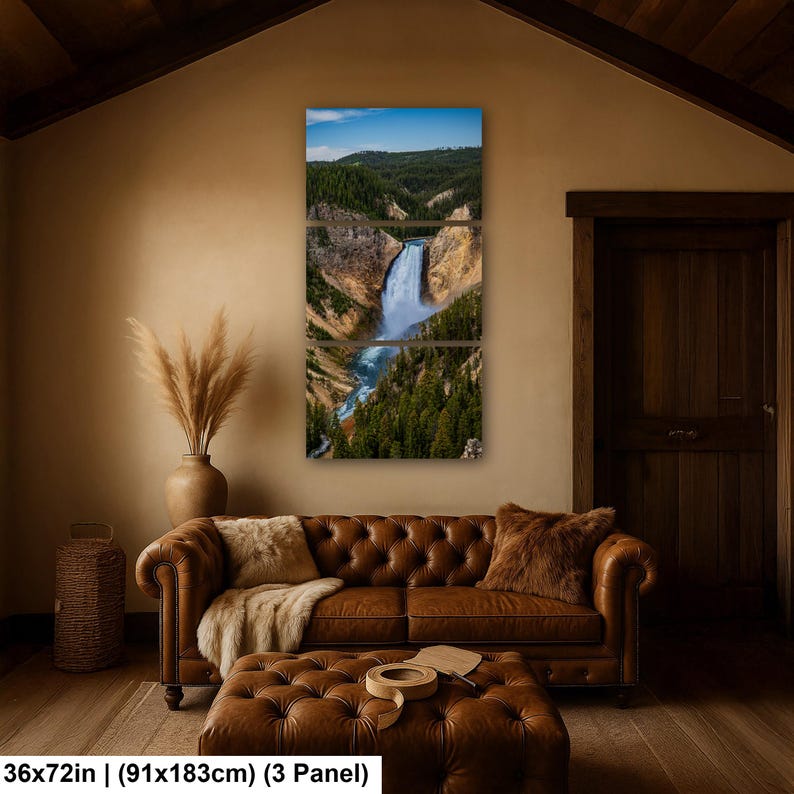 May include: A three-panel wall art set depicting a waterfall cascading through a canyon with green pine forests and rocky cliffs under a blue sky. The artwork measures 36 by 72 inches and is displayed as a vertical triptych on a wall.