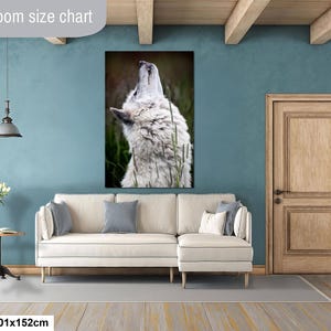 Pu&ograve; includere: Una stampa artistica rettangolare raffigurante un lupo bianco che ulula, posizionata sopra un divano angolare color crema. Il testo Livingroom size chart e 40x60in | 101x152cm sono visibili. Il lupo &egrave; su uno sfondo naturale scuro.