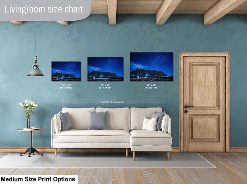 Puede incluir: Una tabla de tama&ntilde;os para sala de estar que muestra tres impresiones de arte mural horizontal sobre un sof&aacute; seccional color crema. Las im&aacute;genes muestran un paisaje monta&ntilde;oso nocturno bajo un cielo estrellado, con medidas de 41x61cm, 51x76cm y 61x91cm.