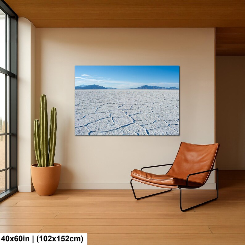 May include: A rectangular wall art print featuring a landscape of the Bonneville Salt Flats with a cracked white salt crust, distant blue mountains, and a clear blue sky. The print measures 40 inches by 60 inches and is displayed on a wall.