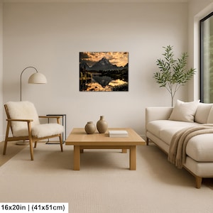 Puede incluir: Una impresi&oacute;n de arte mural rectangular que muestra un paisaje de monta&ntilde;a al atardecer con luz dorada reflej&aacute;ndose en la superficie de un lago tranquilo. La obra mide 41 cm por 51 cm y se exhibe en una pared sobre una mesa de centro.